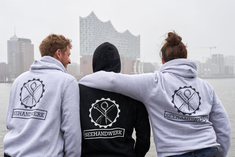 Die drei Gründer des Seehandwerks am Hamburger Hafen vor der Elbphilharmonie